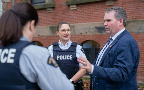 Minister Thompson chats with Superintendent Drummond and Constable Hodder