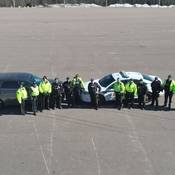 several officers standing in front of two police vehicles