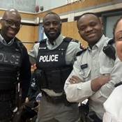 Le gend. Dwight Martin se tient en souriant aux côtés de trois autres policiers dans un gymnase lors d’une activité menée dans le cadre de la Journée de l’excellence des Noirs à Cloverdale Traditional School (de gauche à droite : gend. Dwight Martin, cap. George Amoako, gend. Berthier Kyobela et insp. Veronica Fox)