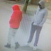 Two suspects standing outside, with their hands in their pockets.