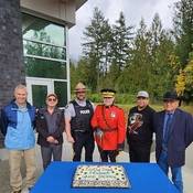 Picture of Village of Gold River Mayor Michael Lott, Village of Tahsis Mayor Martin Davis, Nootka Sound Detachment Commander Sergeant Greg Young, Mowachaht Muchalaht First Nation Chief Nathan George and Chief Jerry Jack, and BC RCMP Commanding Officer Deputy Commissioner Dwayne McDonald cutting the ceremonial cake.