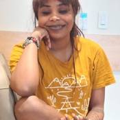 Photo of Shanique Bryan Sitting down wearing a yellow t-shirt