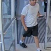 Man wearing white t-shirt, black shorts, black hat