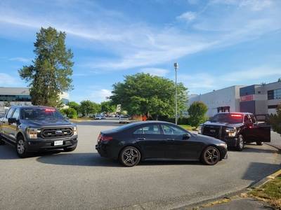 dark colored sedan stopped between two unmarked police vehicles