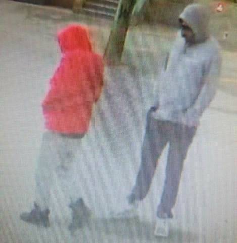 Two suspects standing outside, with their hands in their pockets.