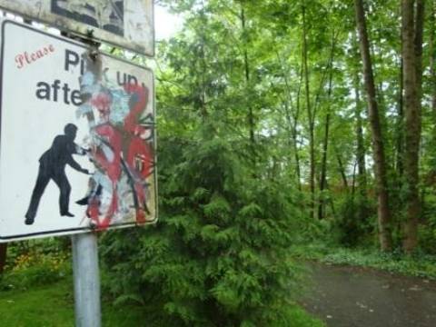 A park sign with graffiti