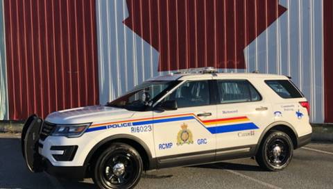 A police car parked in front of a Canadian flag