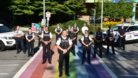Several RCMP members standing on a Project Rainbow crosswalk